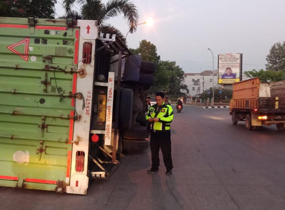Caption : Petugas Satlantas Polres Cirebon Kota saat akan mengevakuasi truck terguling. Foto : Ist