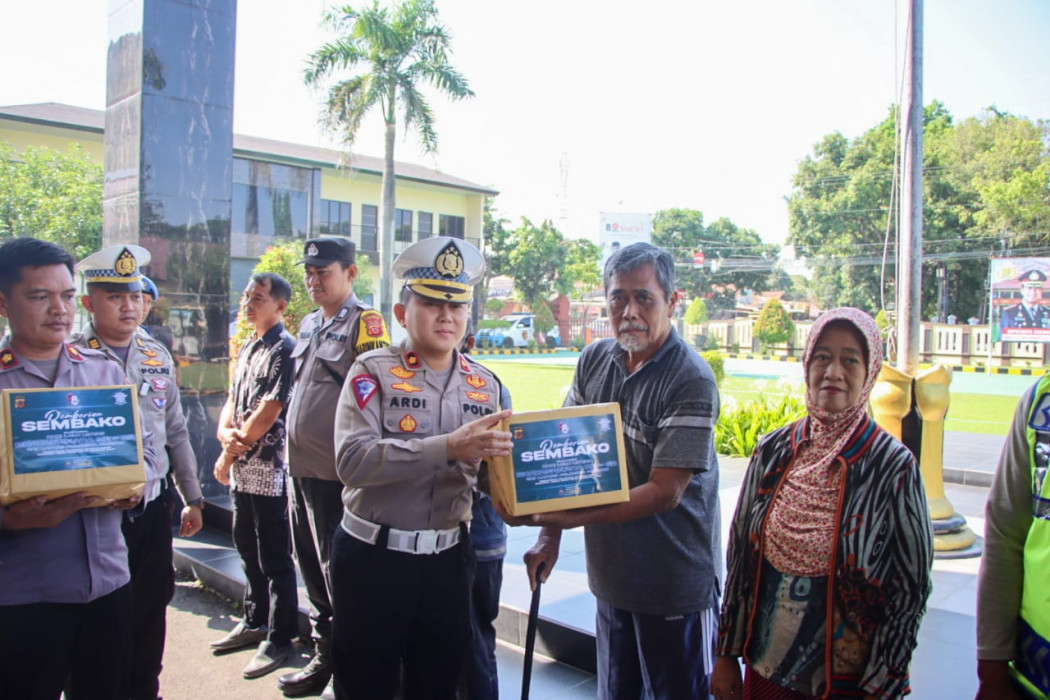 Caption : Kasatlantas Polresta Cirebon, Kompol Ardi Wibowo memberikan bantuan sembako secara simbolis kepada warga di Mapolresta Cirebon. Foto : Ist