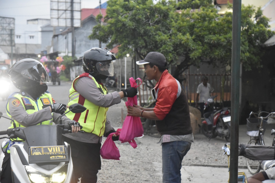 Caption: Kapolresta Cirebon, Kombes Pol Sumarni, saat memberikan bantuan sembako kepada warga di pinggir jalan. Foto: Ist