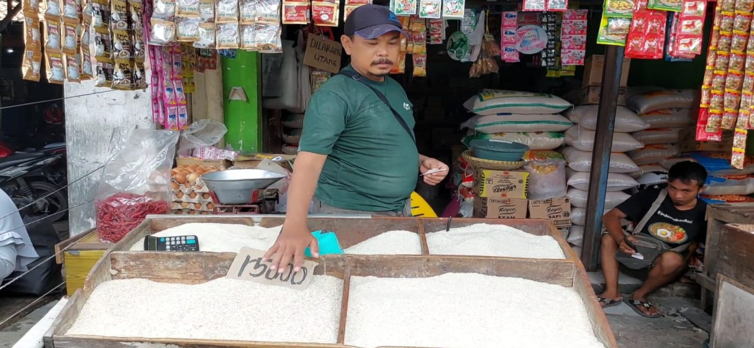 Caption: Edi, seorang pedagang beras di Pasar Tradisional Sumber, Kabupaten Cirebon, saat menunjukkan harga beras dagangannya yang paling murah. Foto: Joni 
